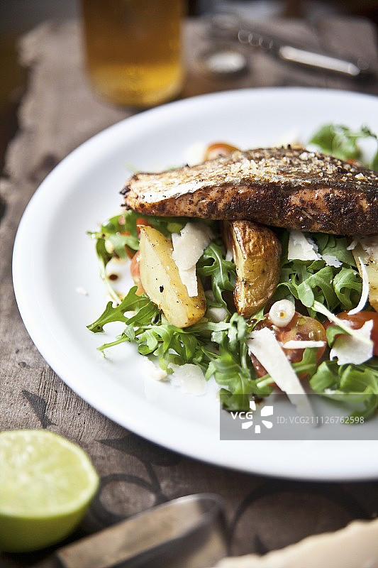 烤卡真三文鱼牛排配薯角和火箭番茄沙拉图片素材