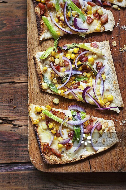 无酵饼配红洋葱、葱、甜玉米、培根和丰蒂纳奶酪图片素材