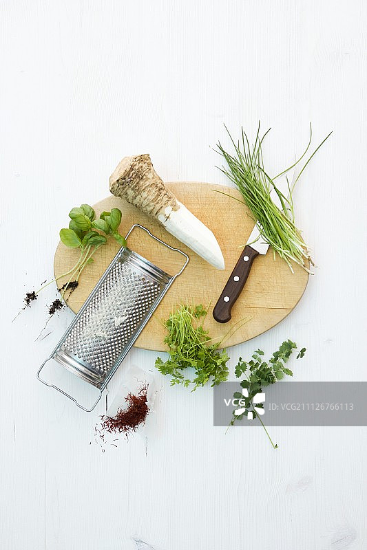 木板上的辣根根、磨碎机和香草图片素材