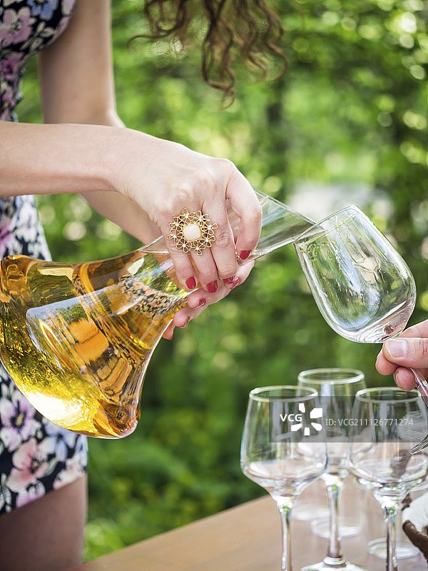 品酒会上，女士将罐中的克维夫瑞葡萄酒倒入酒杯图片素材