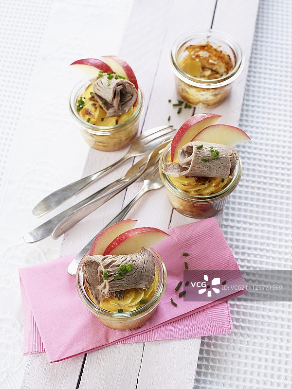 玻璃杯中的焗烤土豆配优质煮牛肉和苹果图片素材