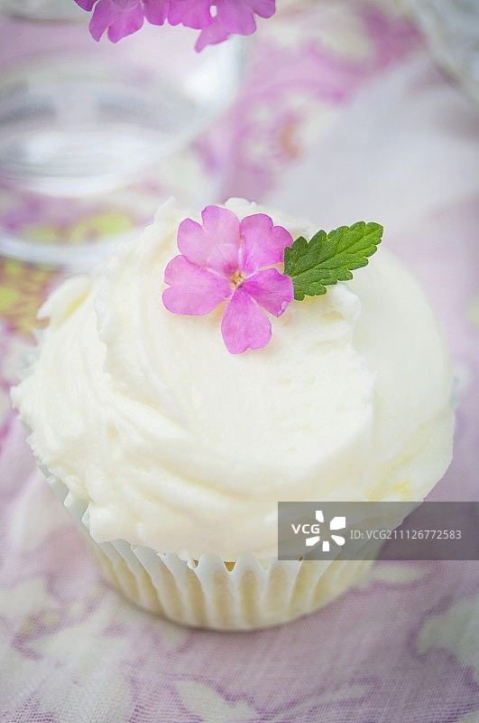 一个带有奶油和鲜花装饰的柠檬纸杯蛋糕图片素材