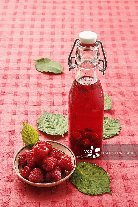 一瓶覆盆子醋和新鲜覆盆子图片素材