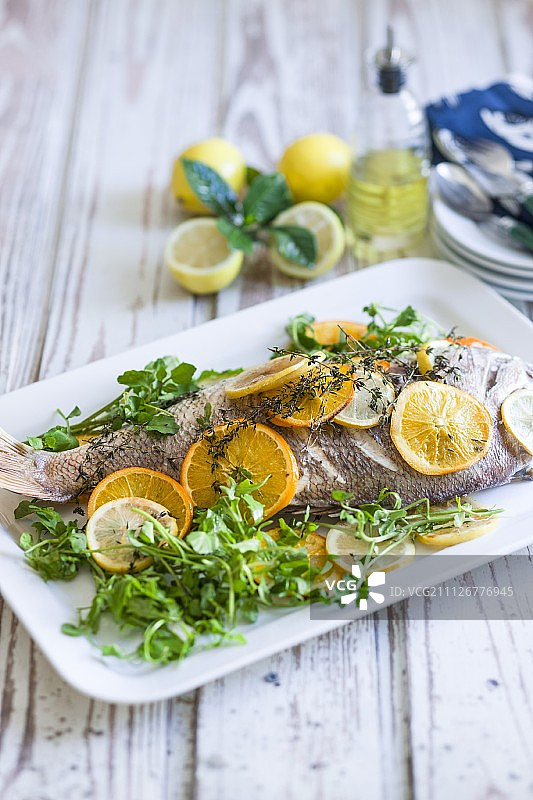 红鲷鱼配柠檬、橙子和新鲜香草图片素材