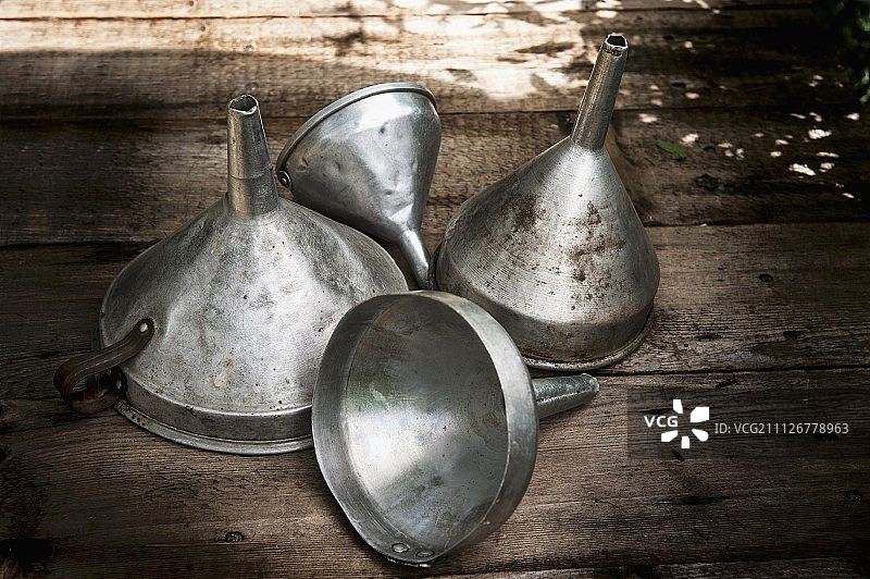 木制表面的旧金属漏斗图片素材