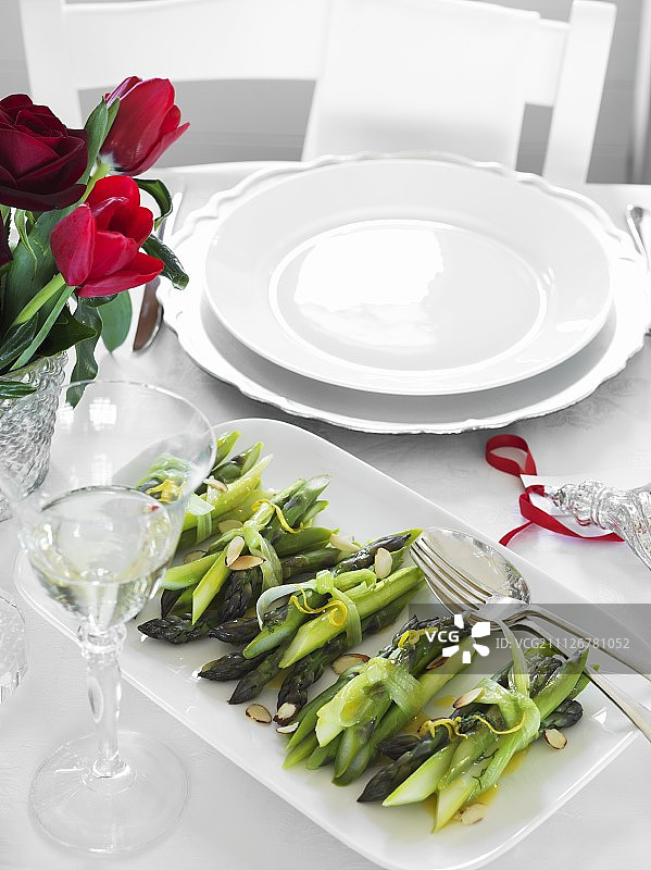 圣诞晚餐餐桌上配柠檬的熟芦笋图片素材