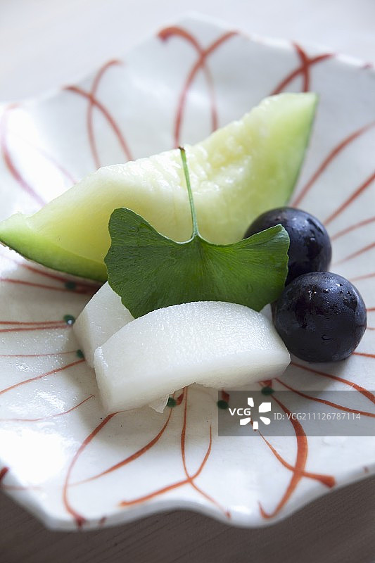 日式生鱼片，配甜瓜、葡萄和银杏叶图片素材