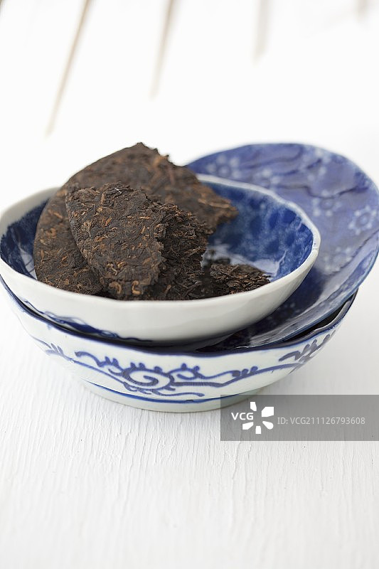 蓝白碗中的普洱茶砖图片素材