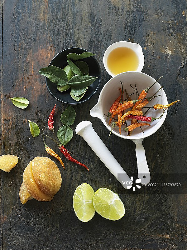 卡菲尔酸橙叶、棕榈糖、酸橙、胡椒和鱼露与研钵和杵图片素材