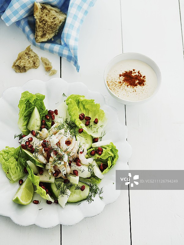 搭配黄瓜、虾、莳萝和石榴籽的长叶莴苣沙拉配酸奶醋汁图片素材