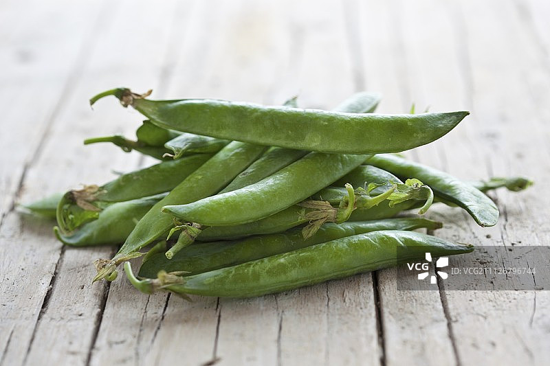木质表面的新鲜豌豆荚图片素材