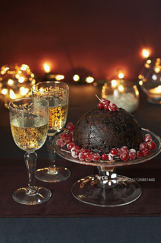 圣诞布丁与红醋栗和两杯白葡萄酒图片素材