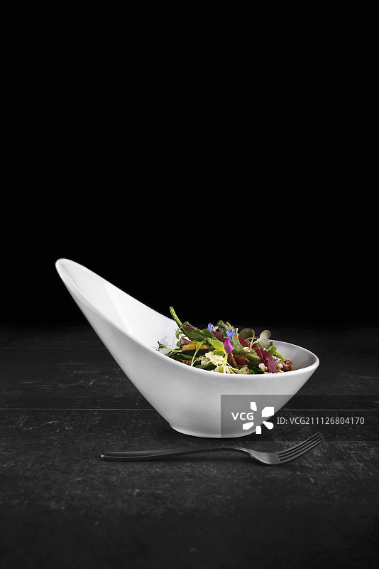 混合沙拉配蜜饯杏仁、羊乳酪、甜菜根和食用花朵图片素材