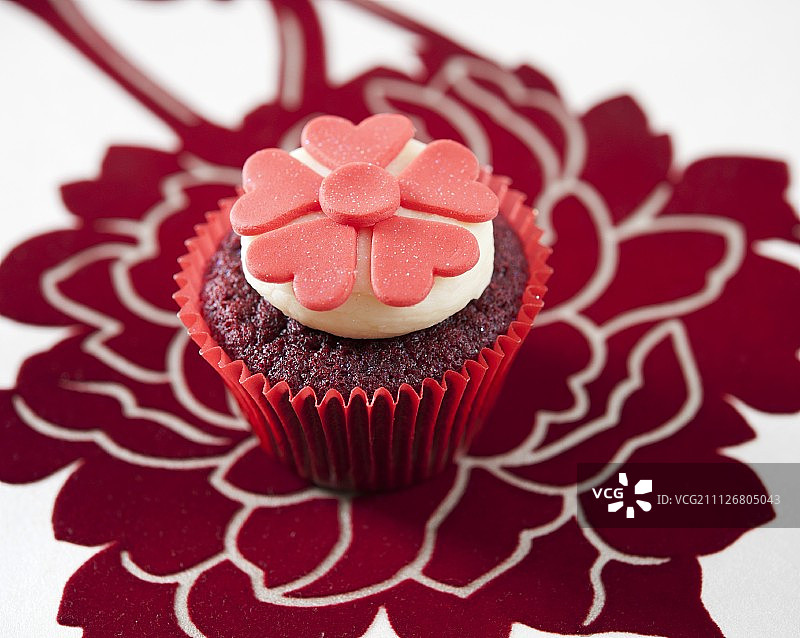 红色天鹅绒纸杯蛋糕，饰有红色翻糖花图片素材