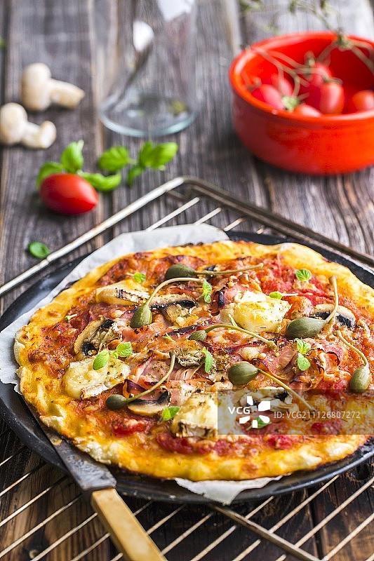 无麸质披萨配火腿、布里奶酪、蘑菇和刺山柑图片素材