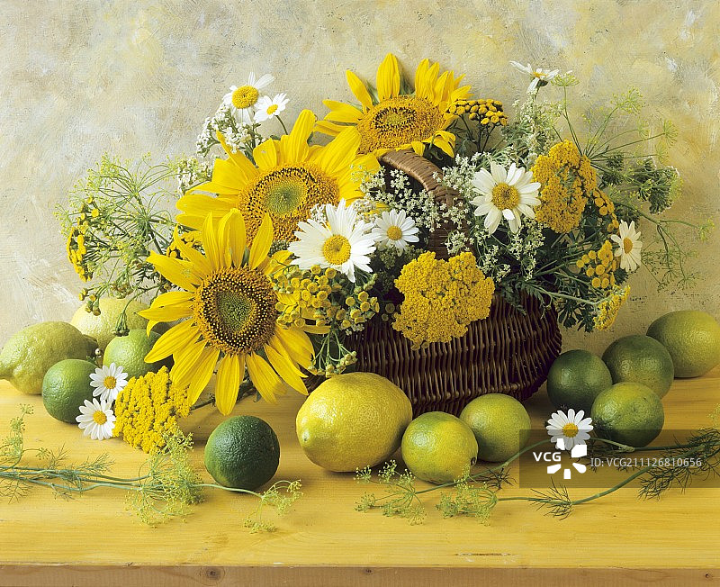 柳条筐里的柑橘类水果和黄色夏季花卉图片素材