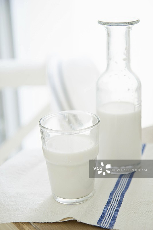 木桌上的玻璃杯和瓶装杏仁奶图片素材