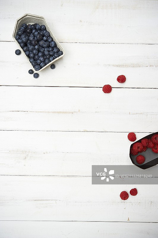 白色木板上的蓝莓和覆盆子图片素材