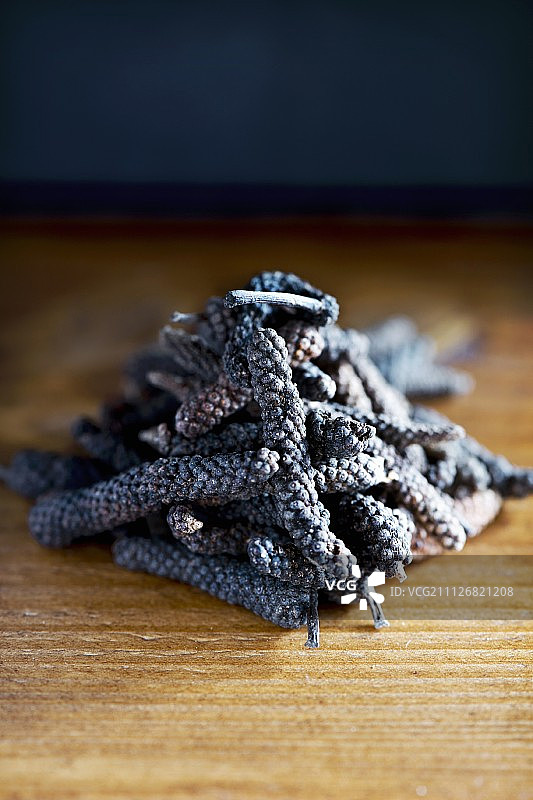 乡村木桌上的长爪哇胡椒特写图片素材