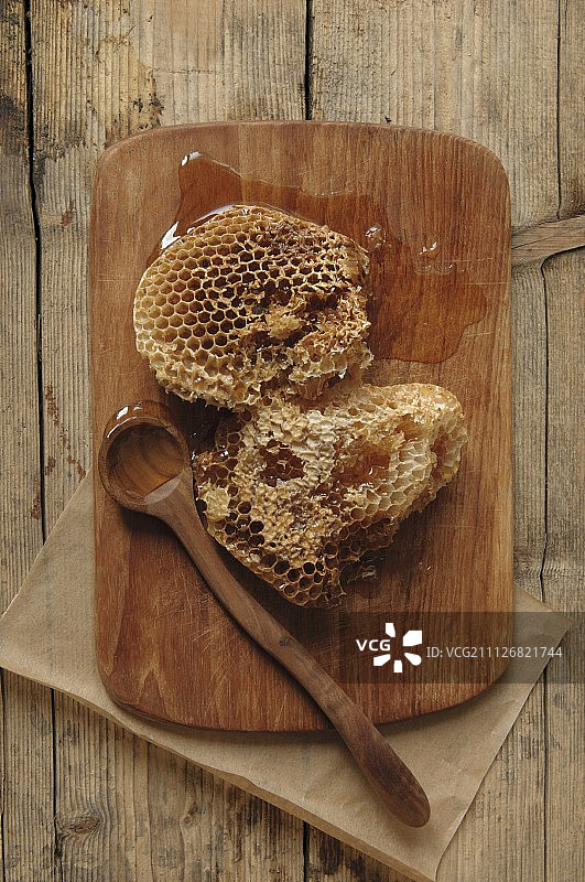 木板上的野生蜂巢与木勺图片素材