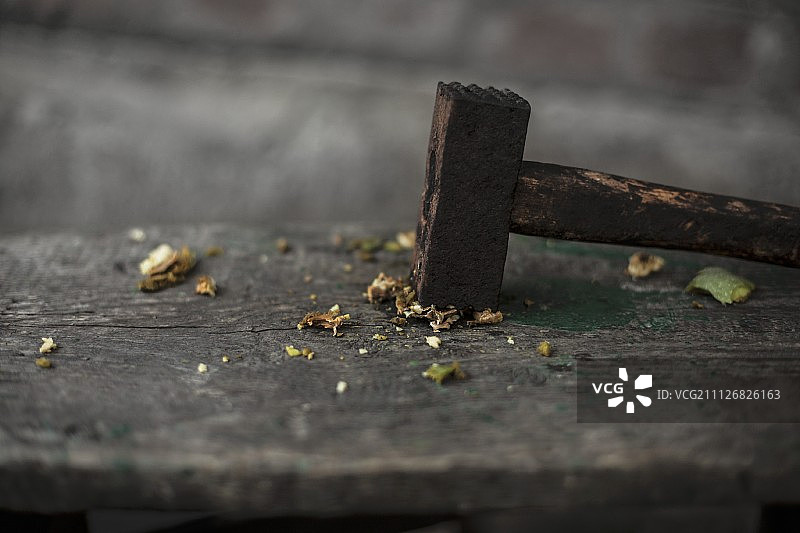 木桌上用锤子砸碎的核桃图片素材