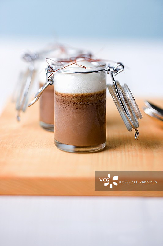 装在罐子里的特级巧克力布丁配酸奶油和辣椒泡沫图片素材