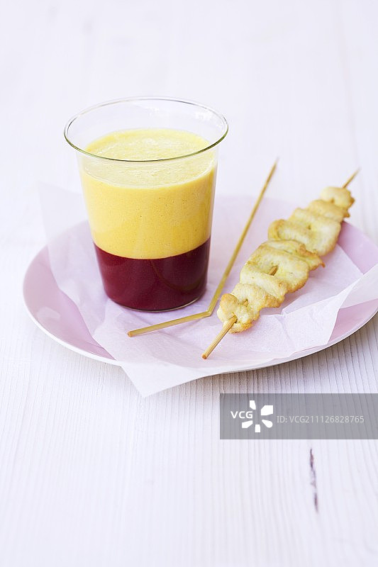 黄色甜椒汤配覆盆子果冻和玉米鸡肉沙爹串图片素材