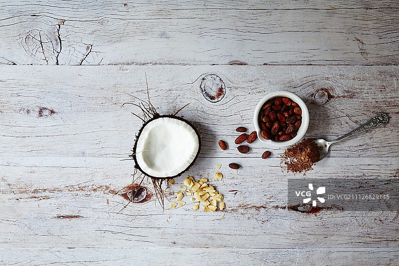 超级食物：木质表面上的椰子、可可和枸杞（俯视）图片素材