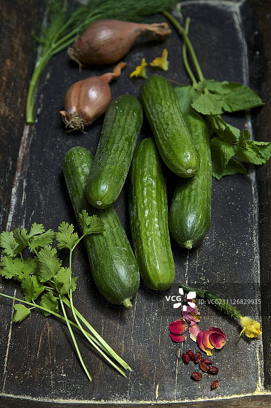 木箱中摆放的有机玫瑰花瓣、香菜、黄瓜、葱、莳萝和薄荷图片素材