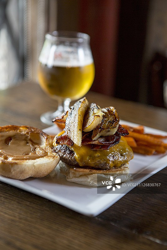 培根烤香蕉芝士汉堡配红薯条和啤酒图片素材