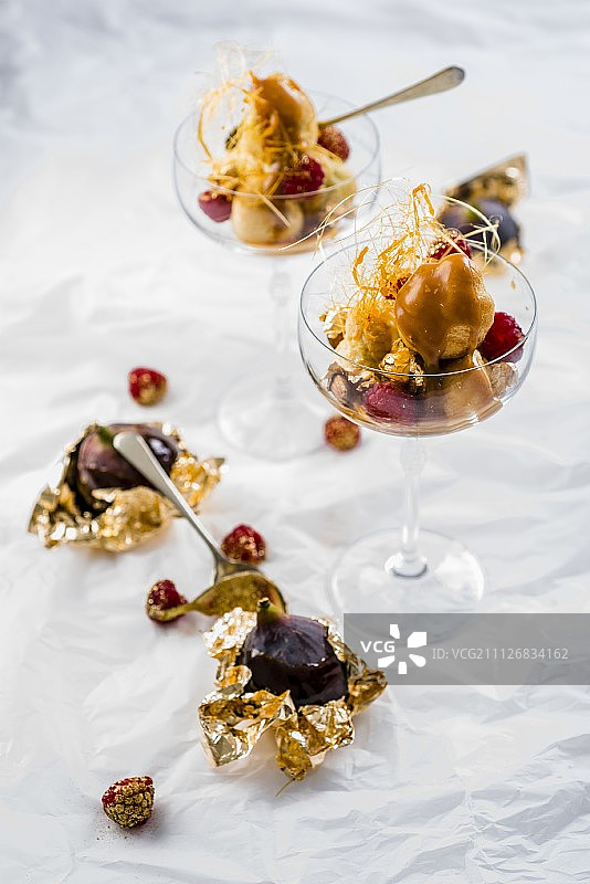 焦糖泡芙塔，配以覆盆子、无花果和金箔图片素材