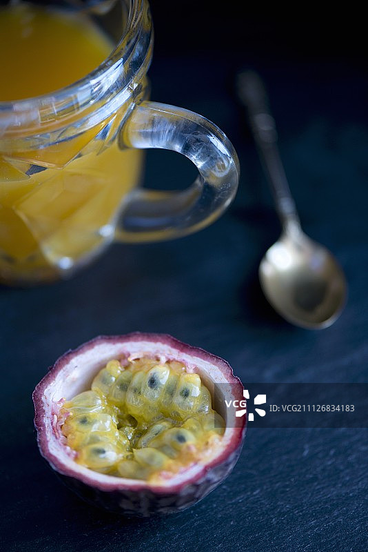 黑色石板上的百香果与果汁图片素材