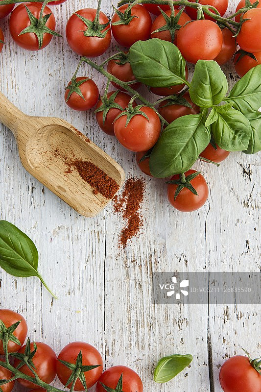 白色木板上的小番茄、罗勒叶和辣椒（俯视）图片素材