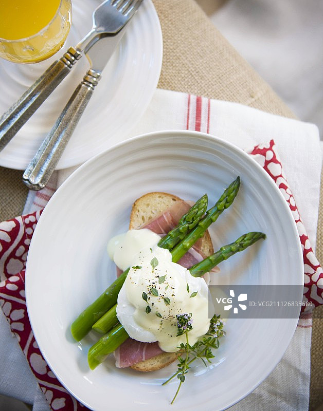 荷包蛋配面包片和火腿，搭配绿色芦笋和荷兰酱图片素材