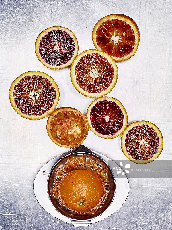 不锈钢榨汁机旁的血橙切半图片素材