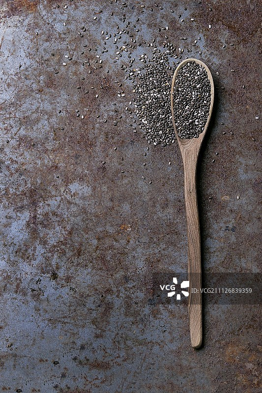 木勺奇亚籽，置于锈迹斑斑的金属表面（俯视）图片素材