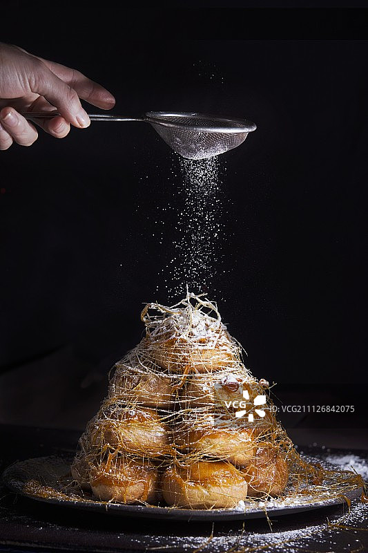 撒着糖粉的焦糖奶油泡芙塔图片素材