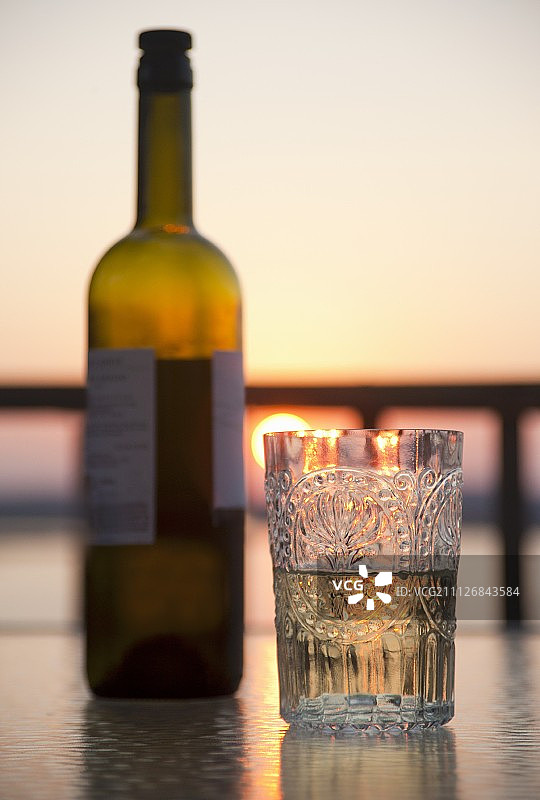 日落时分的水晶玻璃杯中的白葡萄酒图片素材