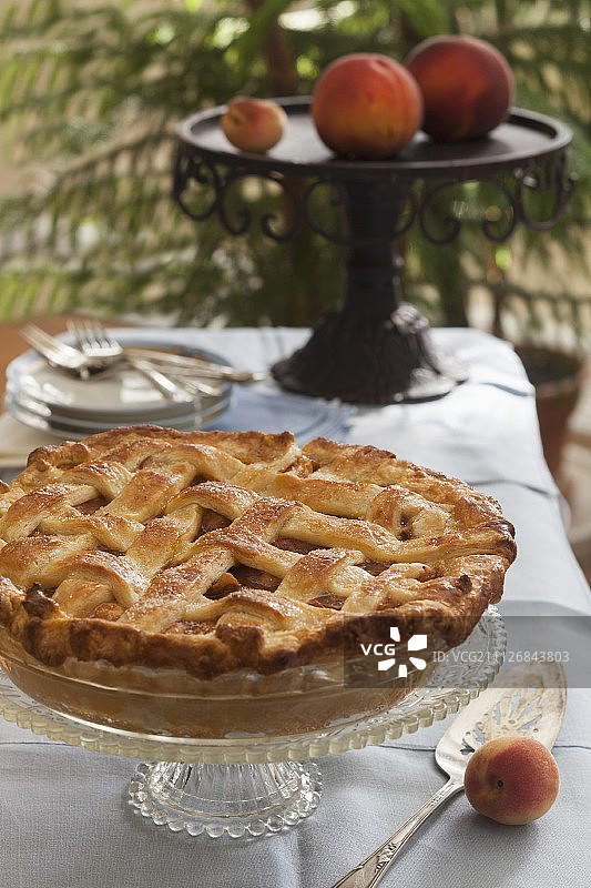带格子盖的完整水蜜桃派，置于蛋糕架上图片素材