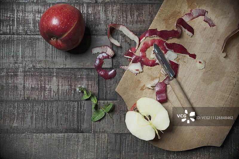 木板上的乔纳德苹果、苹果楔、削皮器和新鲜薄荷图片素材