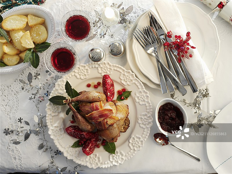 圣诞菜肴：烤野鸡配培根、石榴和土豆图片素材