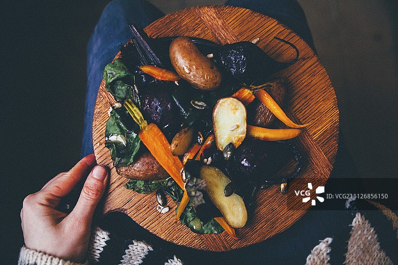 一位女士手持烤蔬菜木板图片素材