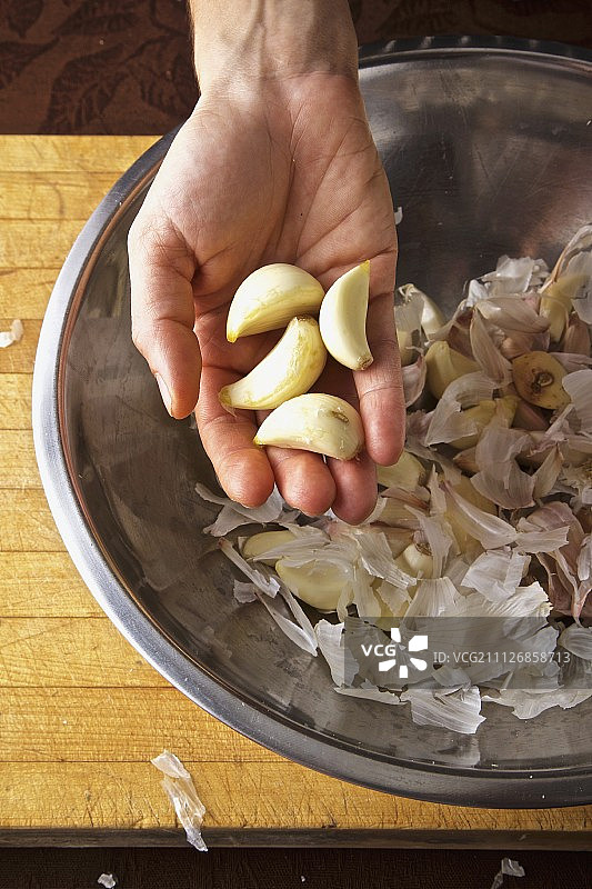 手持剥皮的有机大蒜图片素材