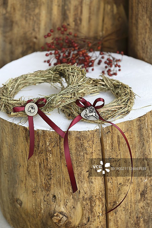 白色树干上装饰着红色蝴蝶结的两个干草圈图片素材