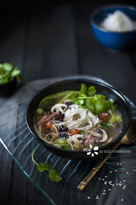 用猪蹄汤和肉、蘑菇、八角、白菜、辣椒、芝麻、味噌和面条制成的东方肉汤图片素材