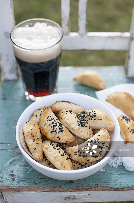 黑布丁馅烤饺子，撒上黑色香菜籽，搭配一杯黑啤酒图片素材