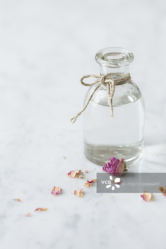 玫瑰水玻璃瓶与玫瑰花瓣图片素材