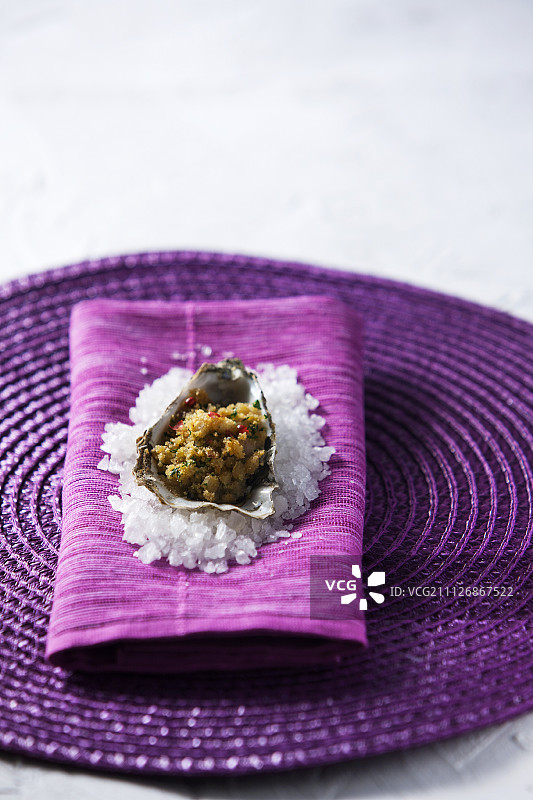 炸牡蛎佐盐，配紫色餐巾和餐垫图片素材