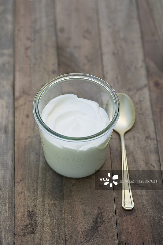 玻璃杯里的天然酸奶和茶匙图片素材