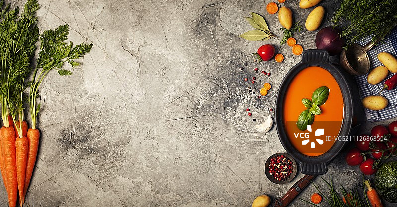 灰色石板背景上的黑碗自制蔬菜汤图片素材